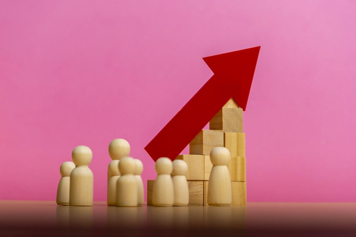 Wooden blocks and figures accompany an up arrow