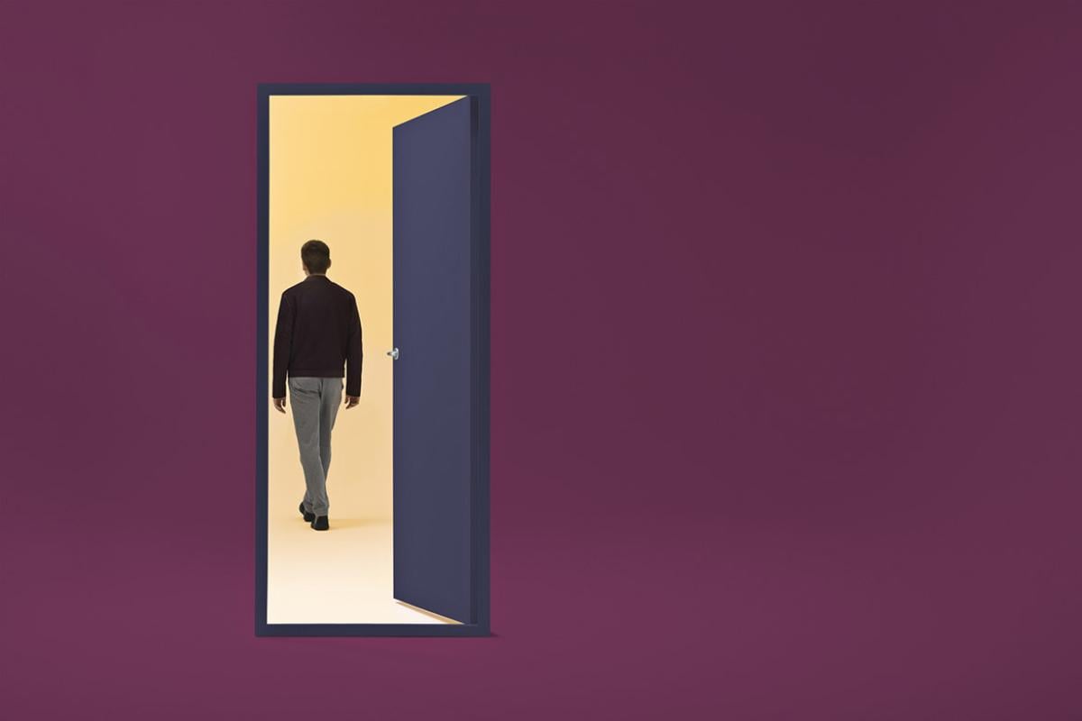 Figure walks through an open door