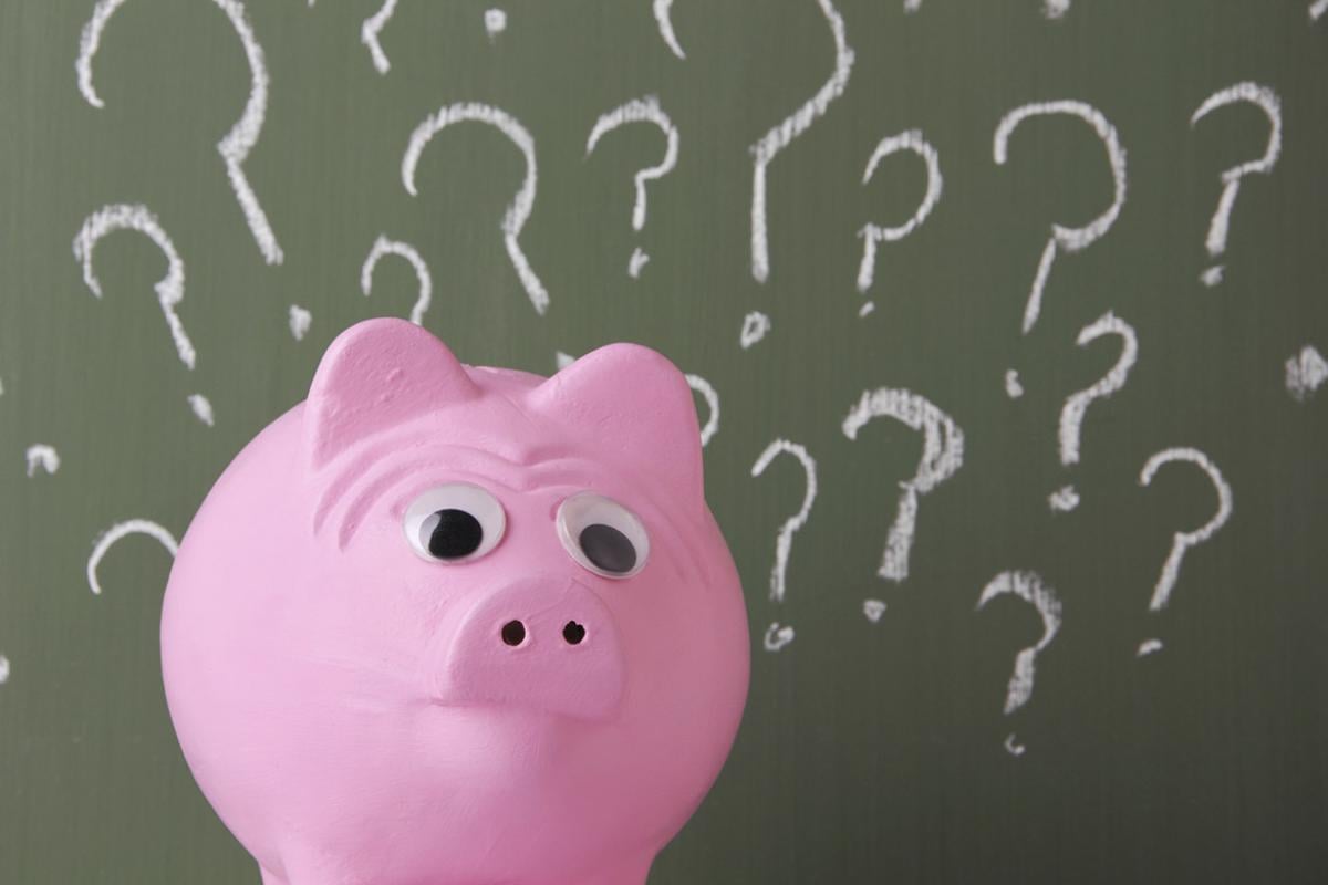 Piggy bank surrounded by question marks
