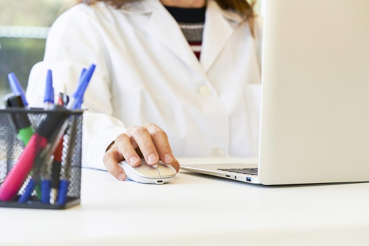 Scientist using laptop and mouse in laboratory