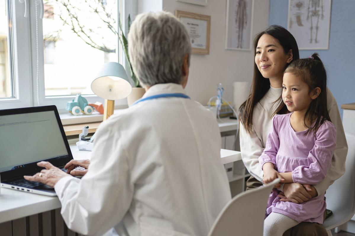 Parent holds child during doctor's appointment