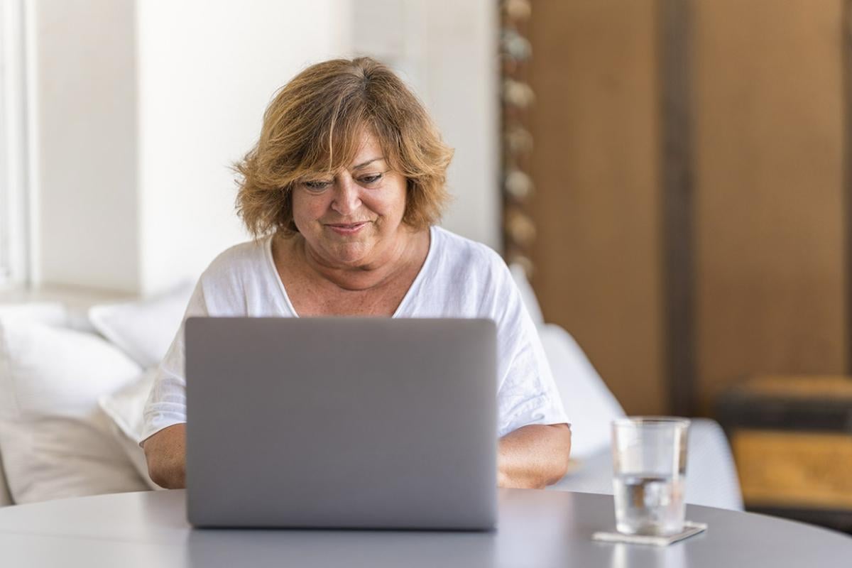 Smiling woman works at a laptop