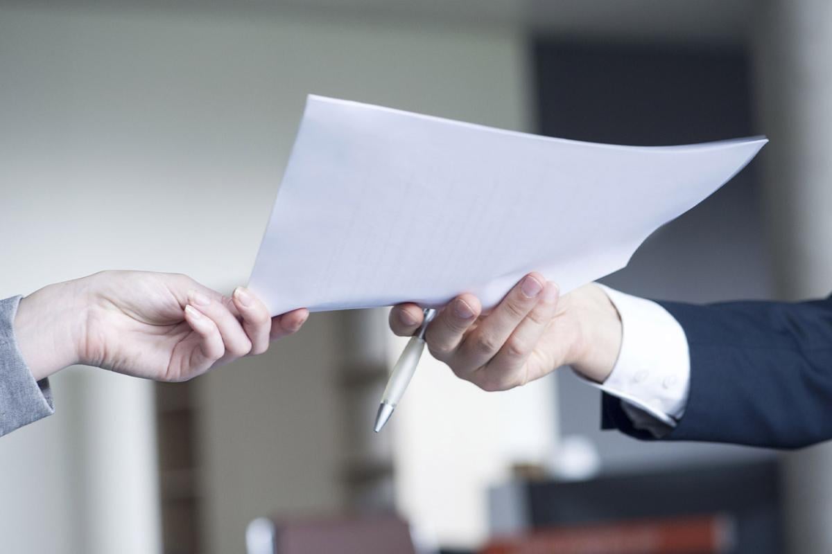 Colleague handing document to another colleague