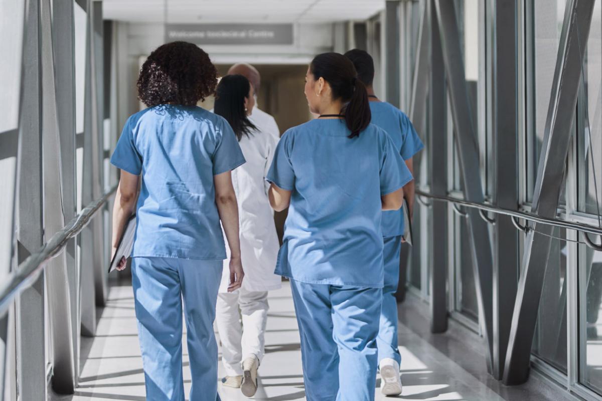 Group of health care workers walk down a hallway