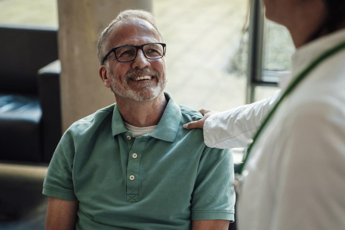 Smiling patient looks up at doctor