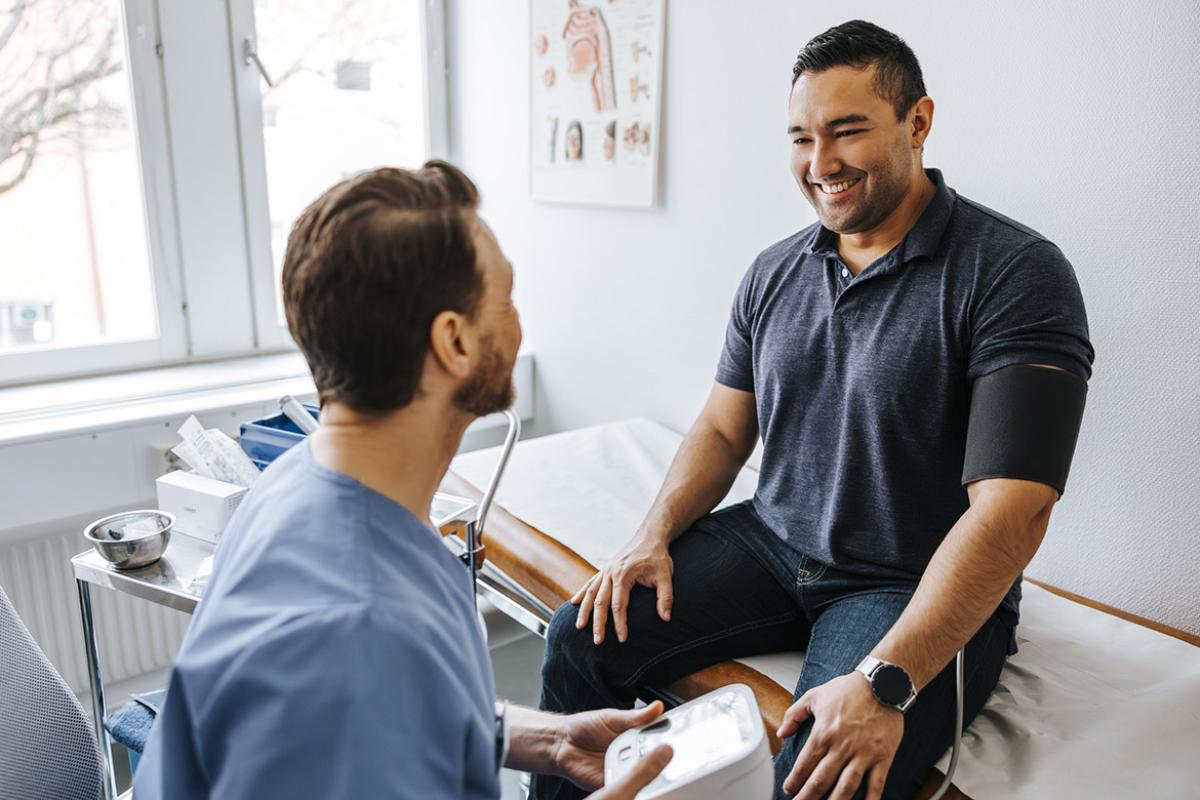 Smiling patient getting blood pressure checked by physician