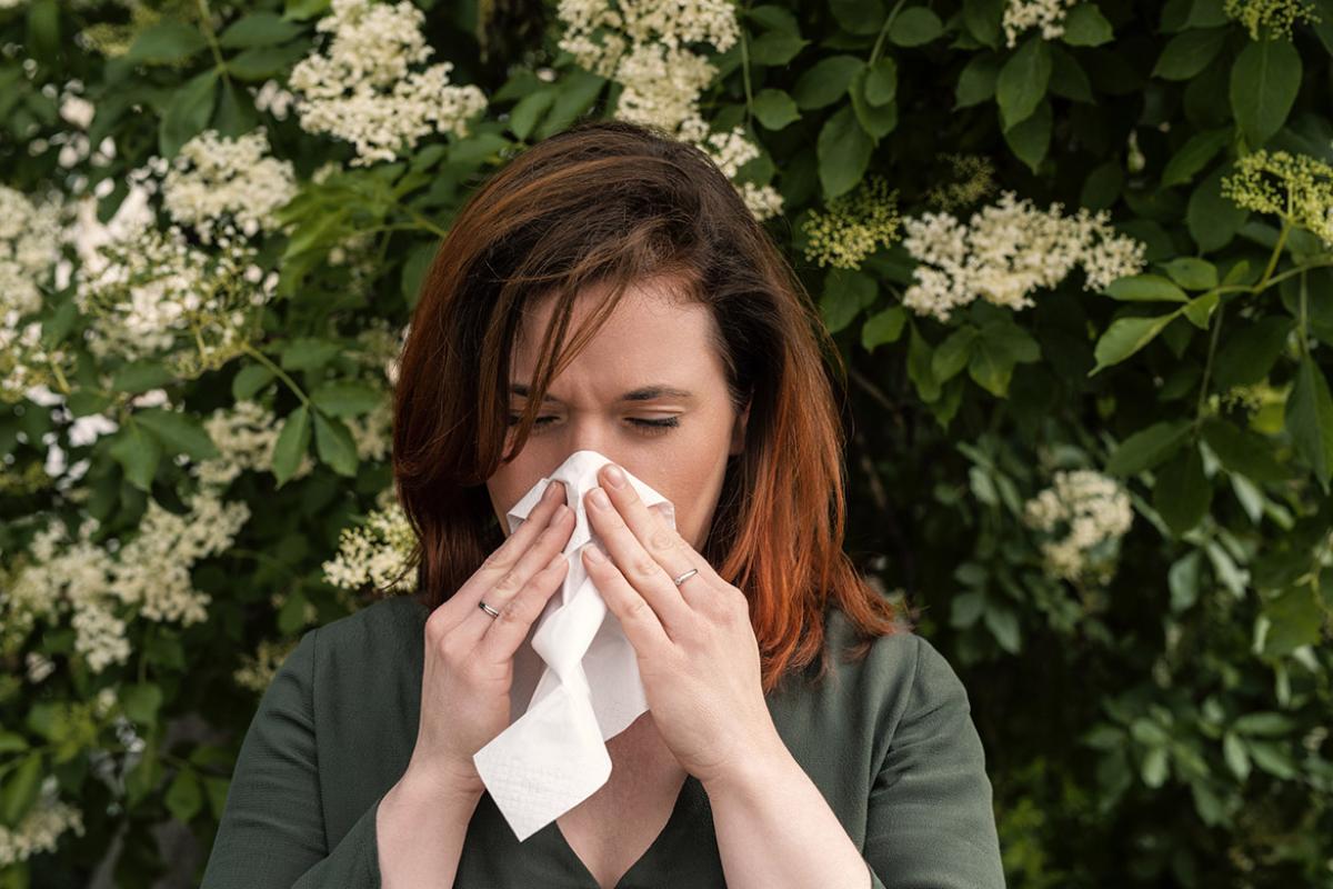 Person sneezes into a handkerchief
