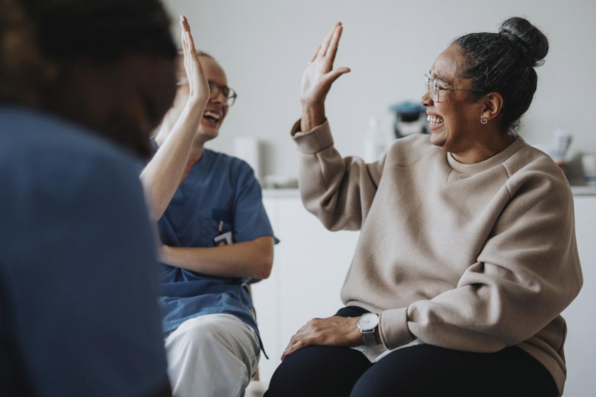Two smiling people high five