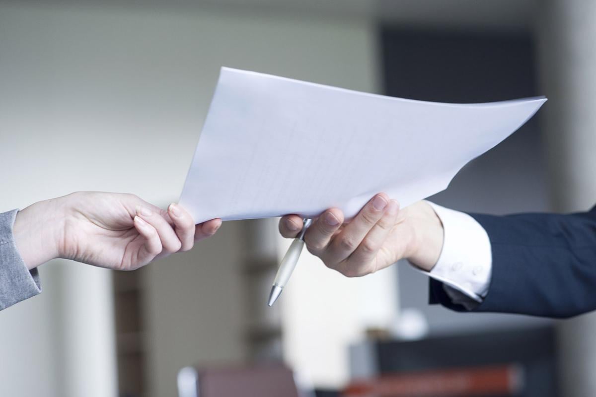 Hand passes a piece of paper to another hand