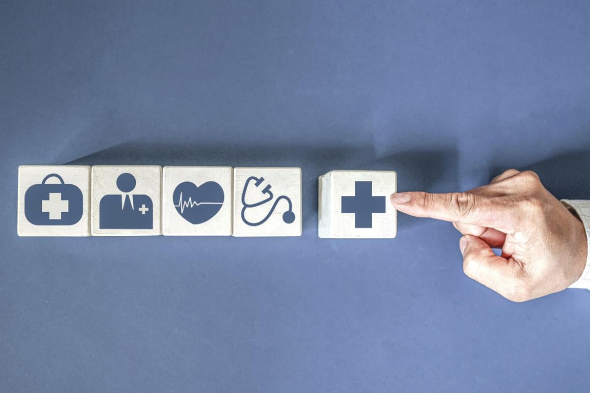 Finger points to blocks with healthcare icons