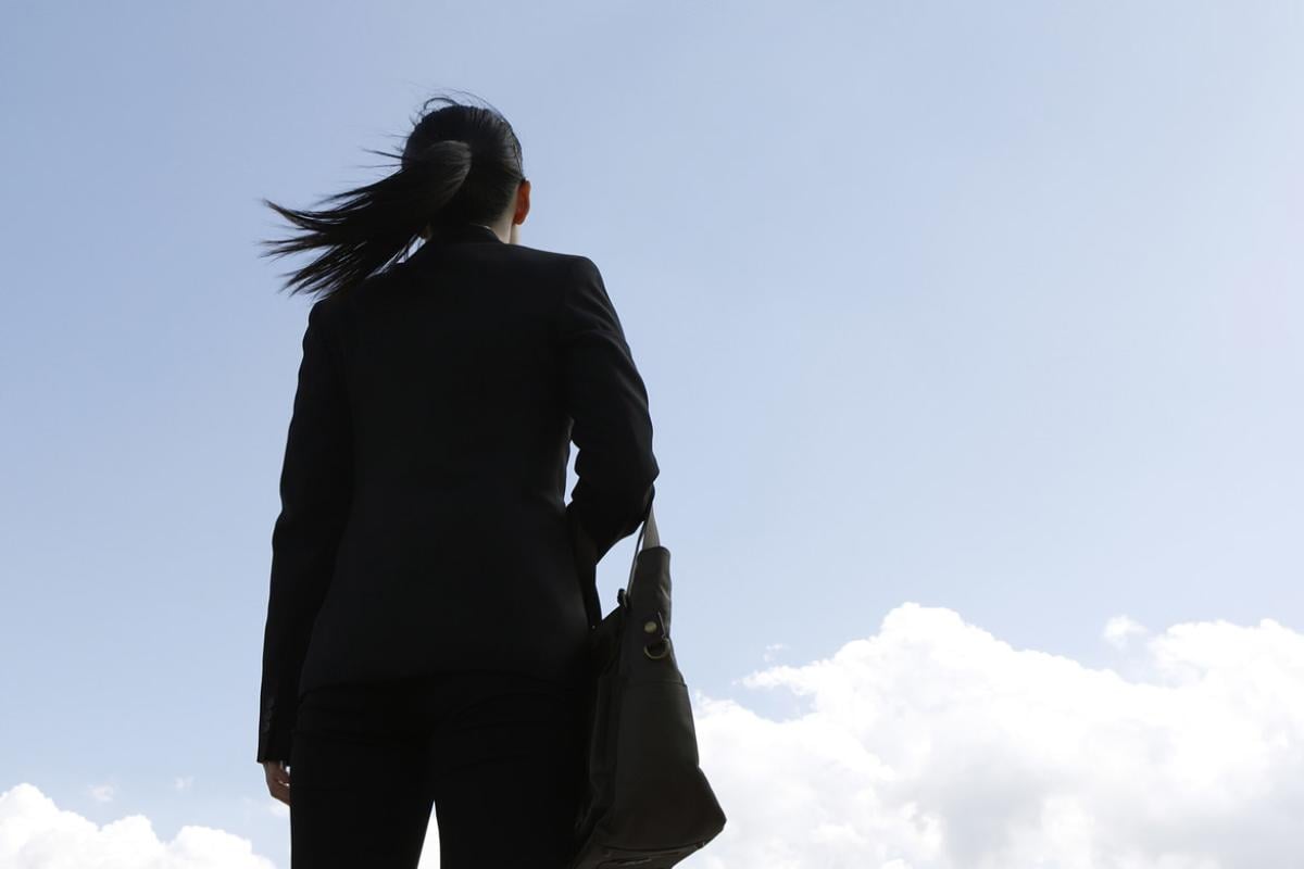 Businessperson looking up sky 