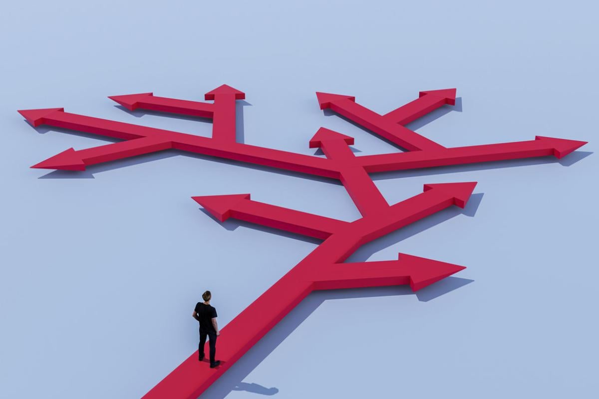 Figure stands at paths in different directions