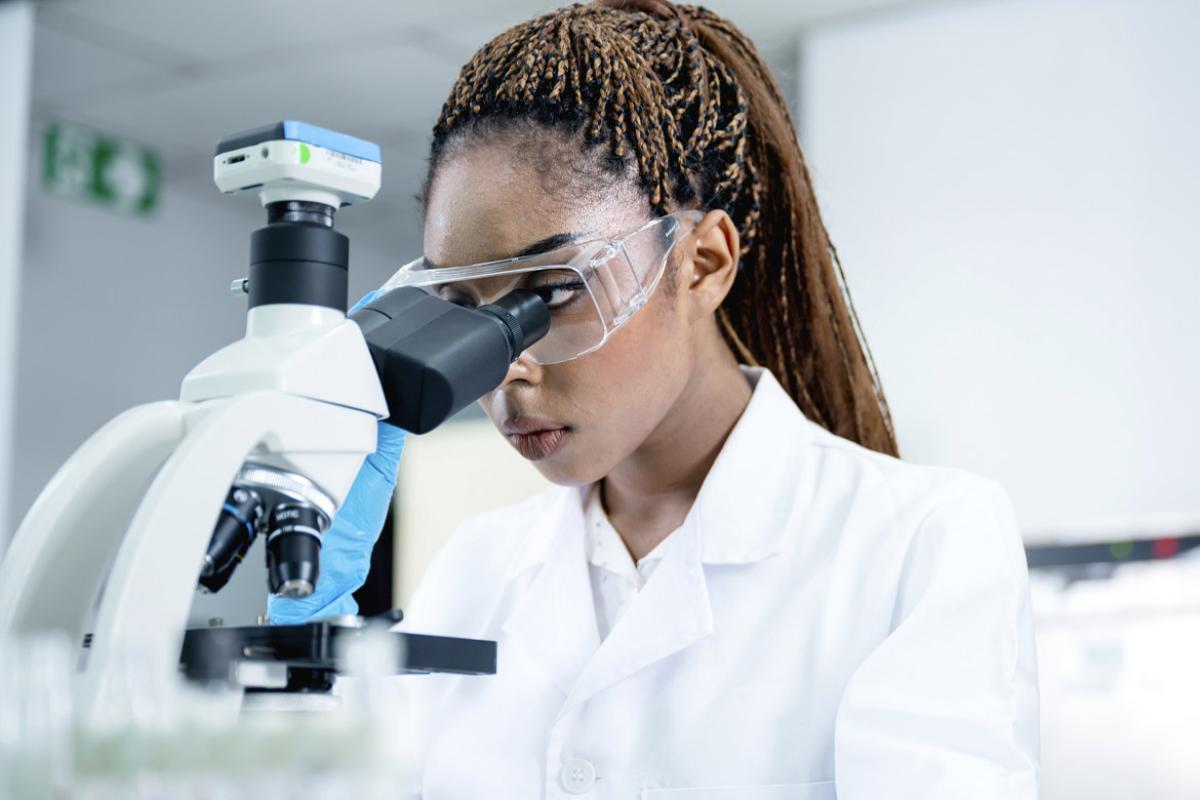 Scientist in a lab using a microscope