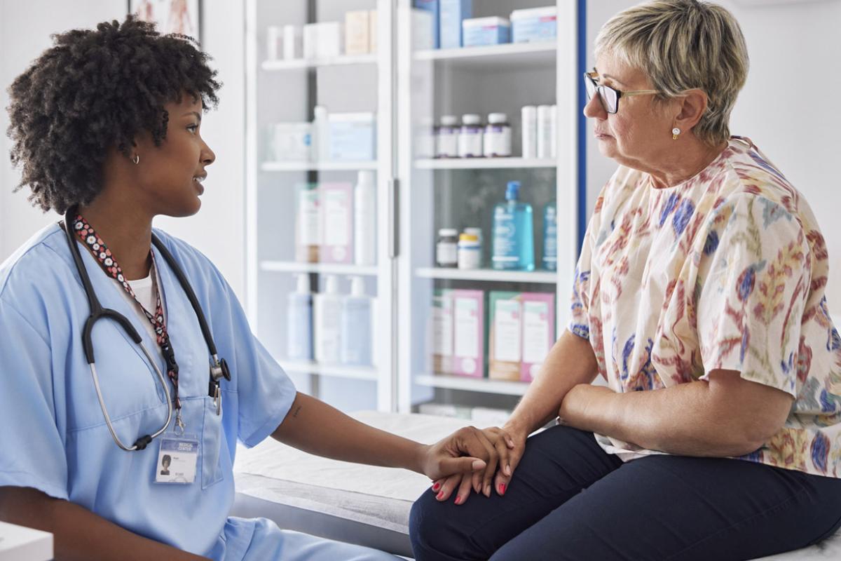 Physician with reassuring hand on patient