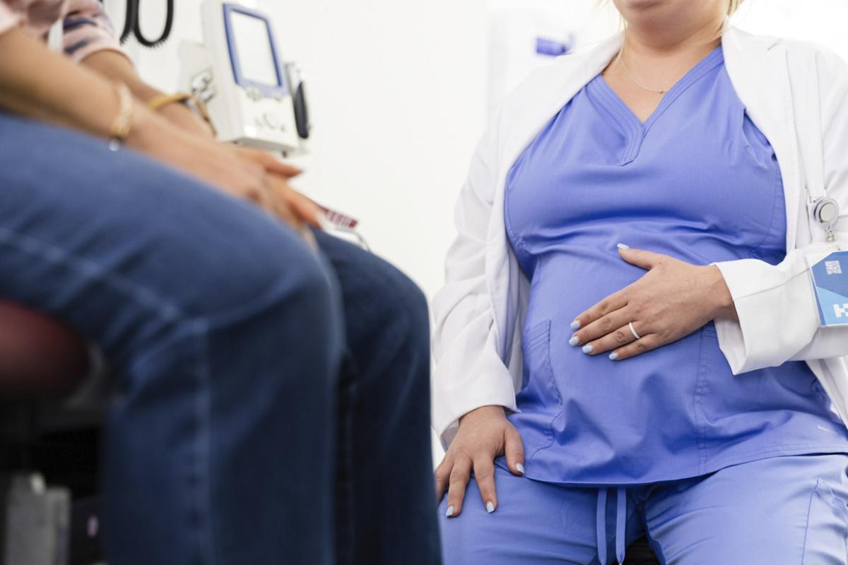 Pregnant physician with a patient