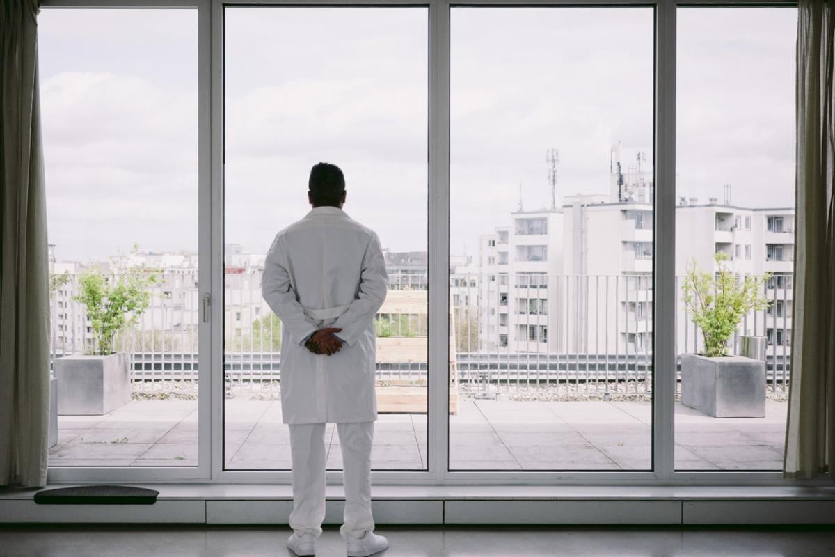 Physician stands in front of a window