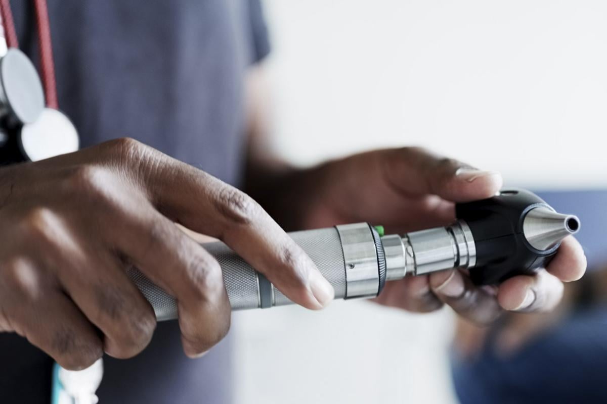 Physician holding otoscope