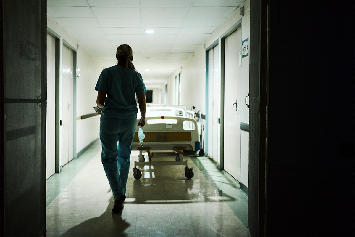 Physician walks through a dimmed hallway
