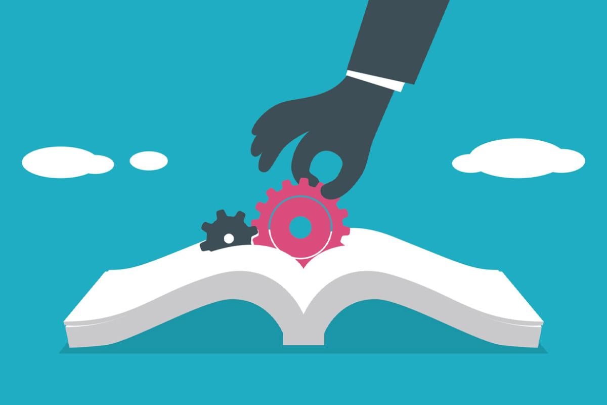 Hand pulls a gear from an open book
