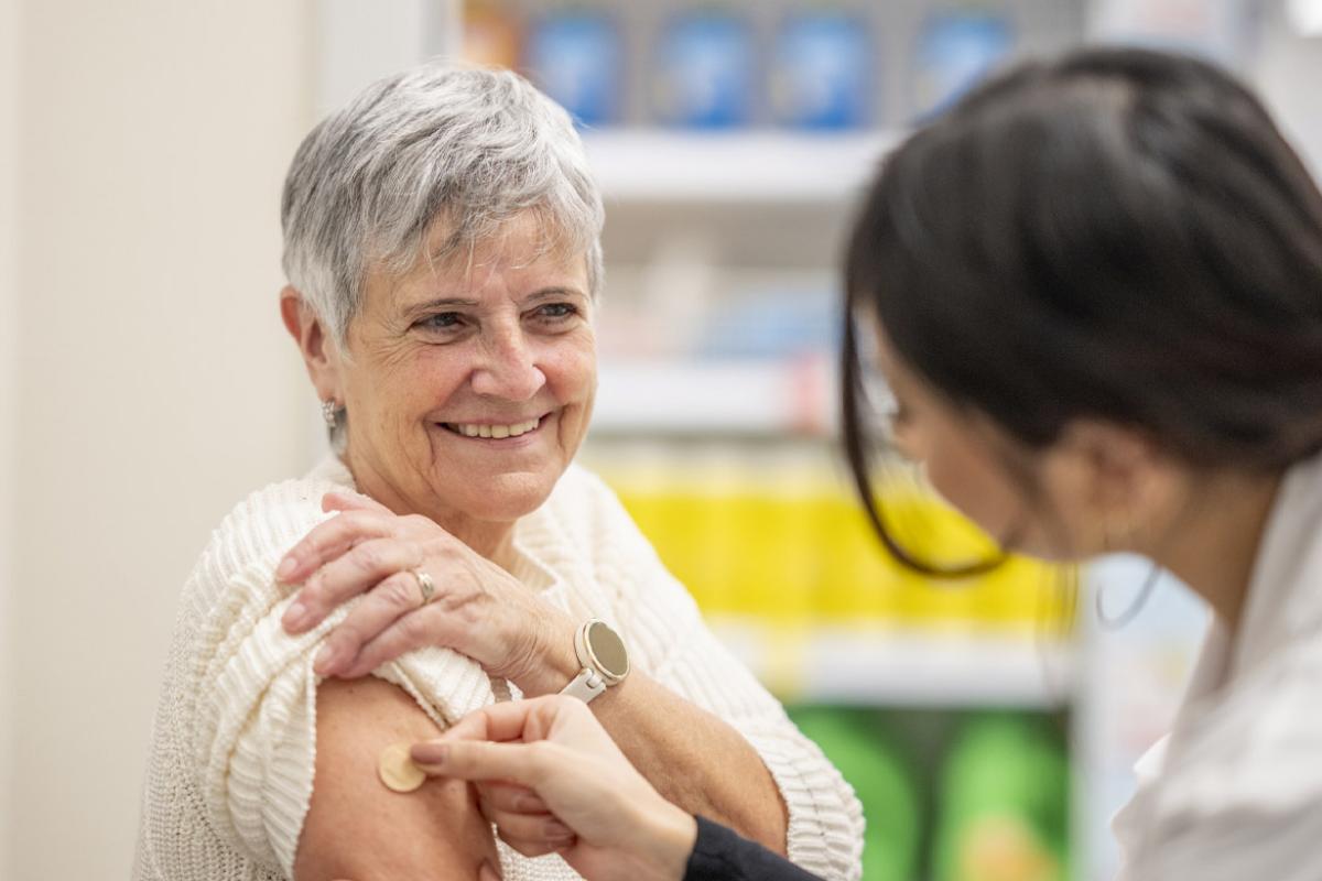 Healthcare worker places bandage on smiling patient