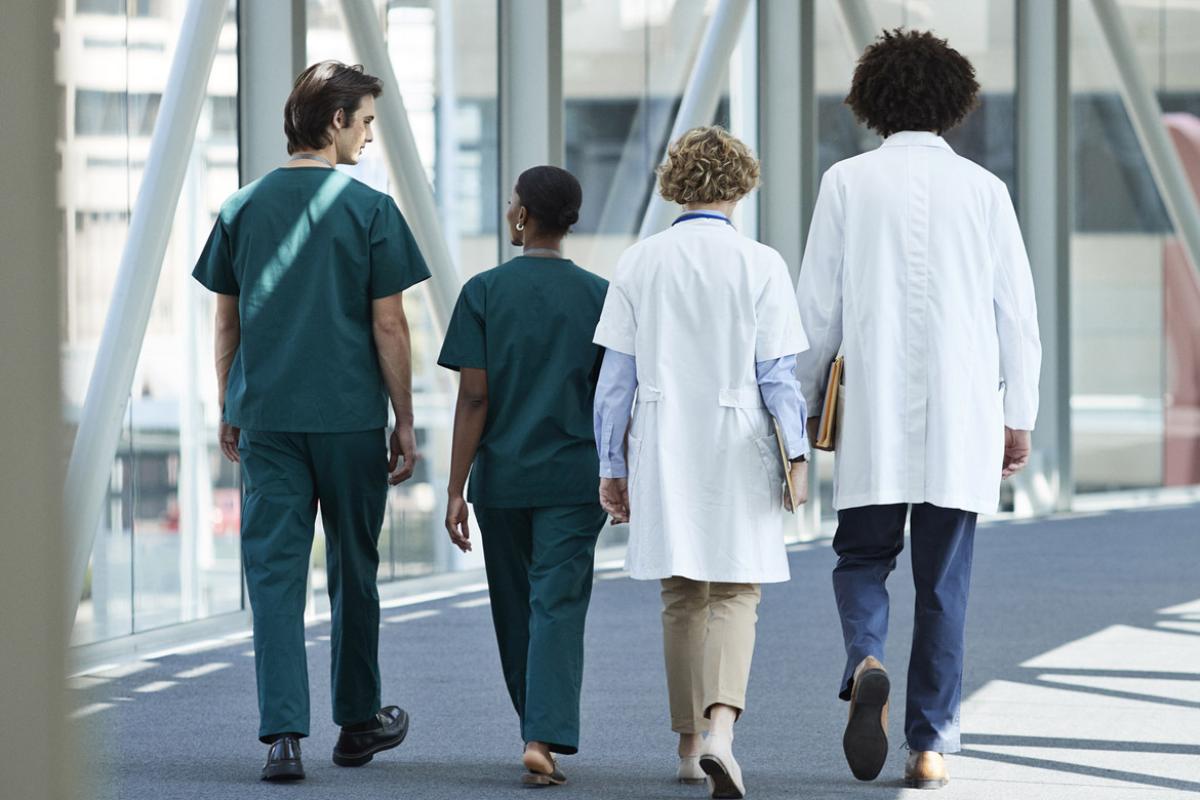 Group of physicians walk down a hallway