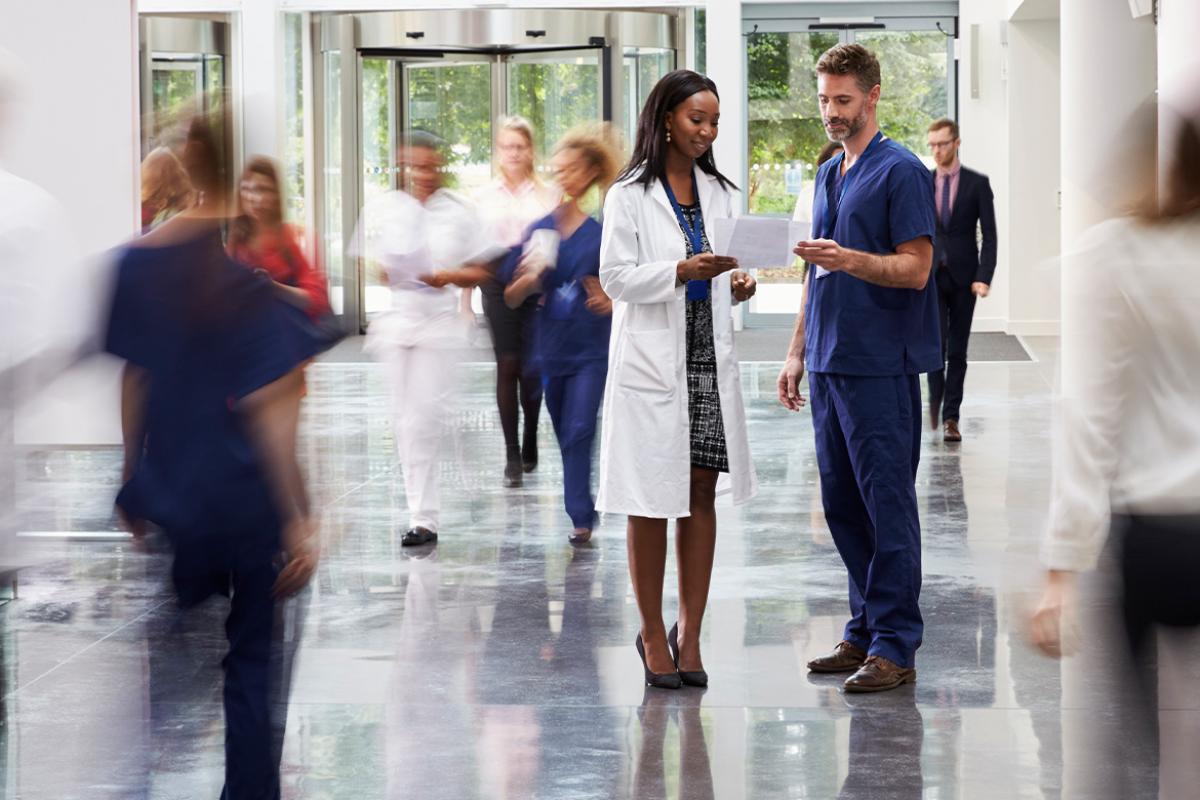 Two physicians in a busy hallway
