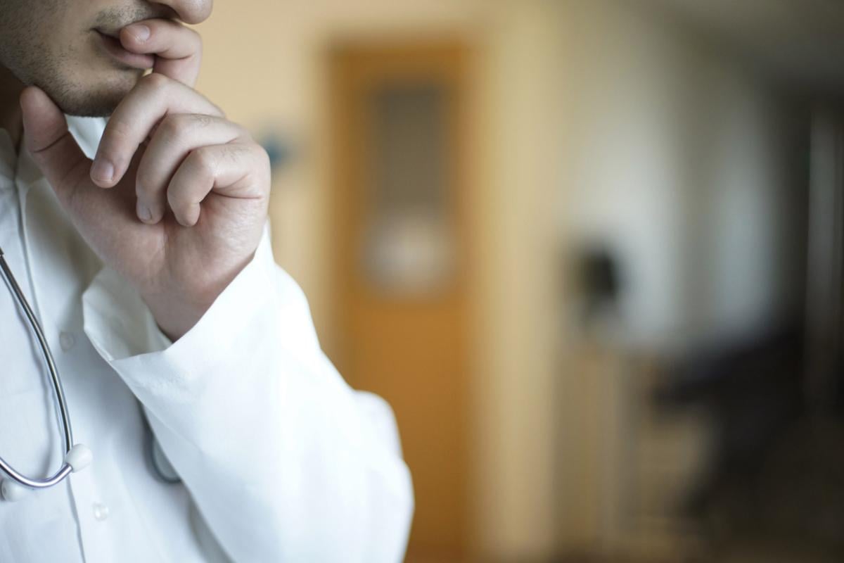 Thoughtful doctor with hand on chin