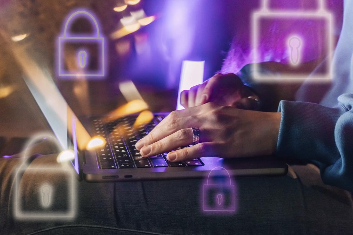 Hands on a laptop surrounded by IT security lock symbols