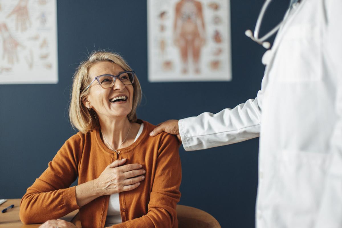 Physician with hand on smiling patient's shoulder