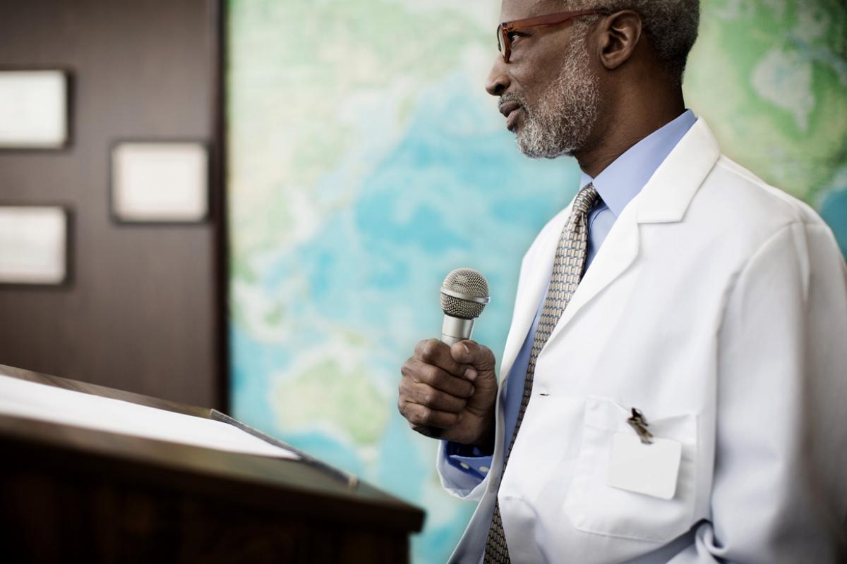 A gray-haired physician leads a seminar to teach other physicians how to be leaders as the health care system changes.