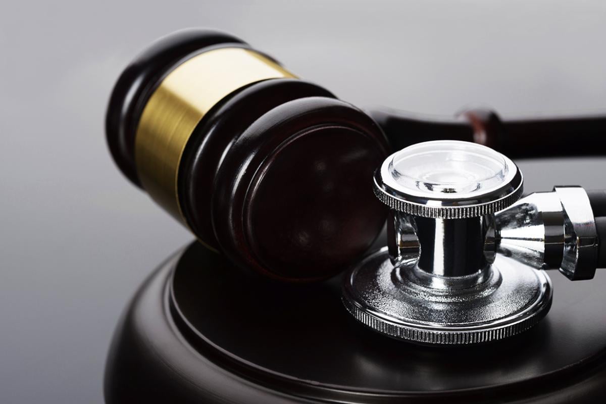 Close-up of gavel and scope resting on a desk.