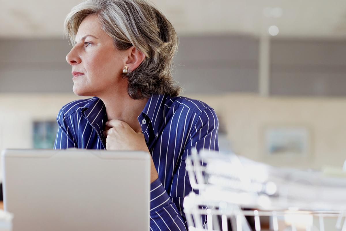 Middle-aged woman sitting in front of laptop.