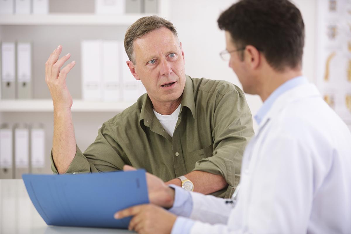 Physician shares chart with surprised patient.