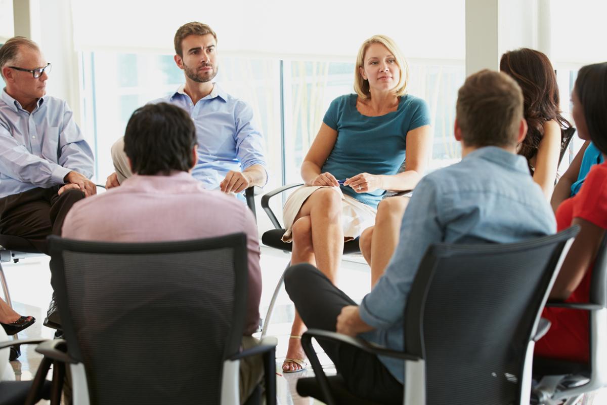 People sit in a circle for a therapy session.