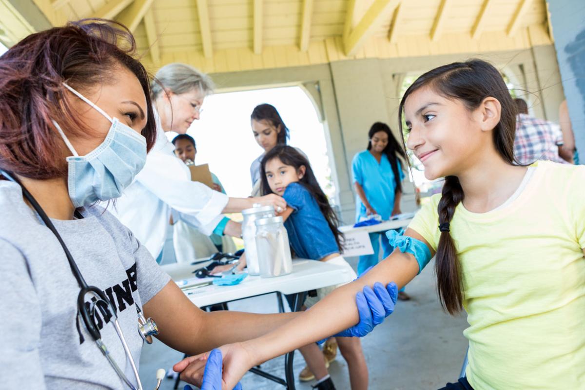Physician treats young patient in makeshift clinic. 