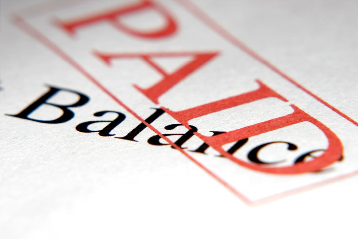 Image of the word 'balance' on a piece of paper stamped with 'paid'. 