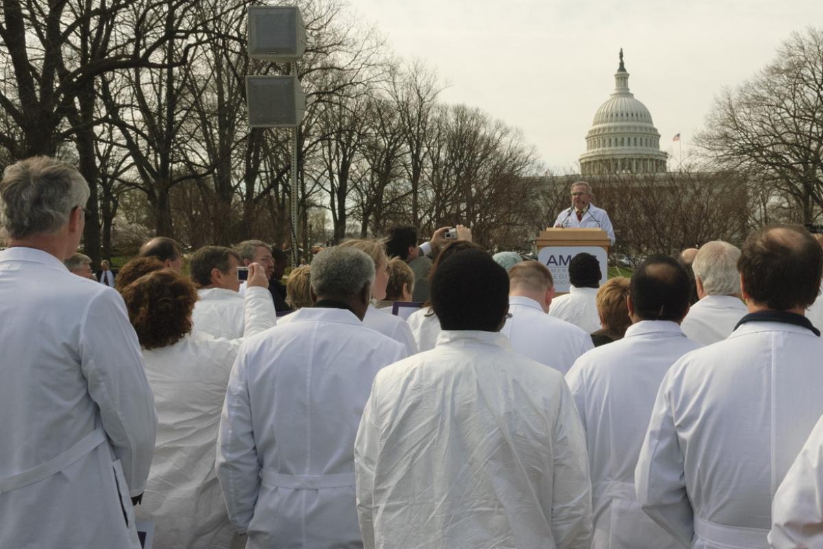 Doctors in medical coats listen to a speech at an AMA rally outside the U.S. Capitol. 