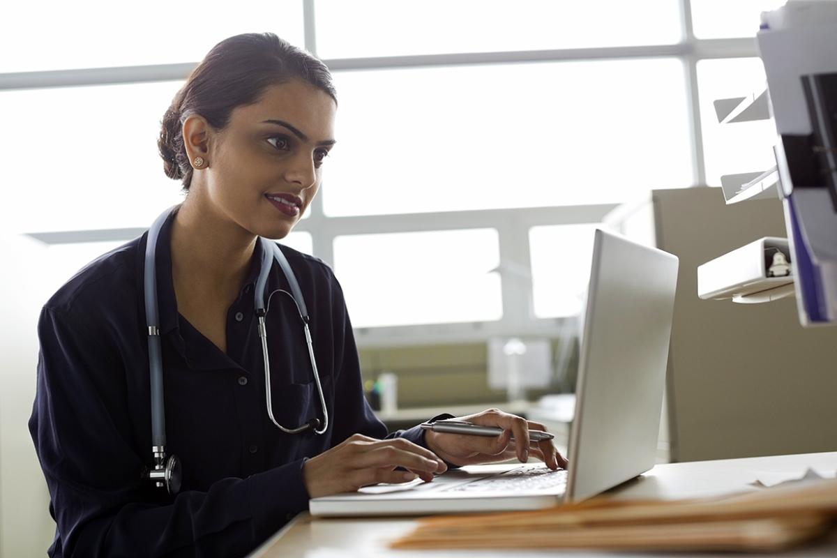 Medical professional reviews information on computer.