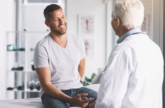 Man sitting on exam table in front of physician