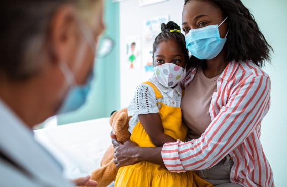 Parent and child at the doctor's office, wearing masks