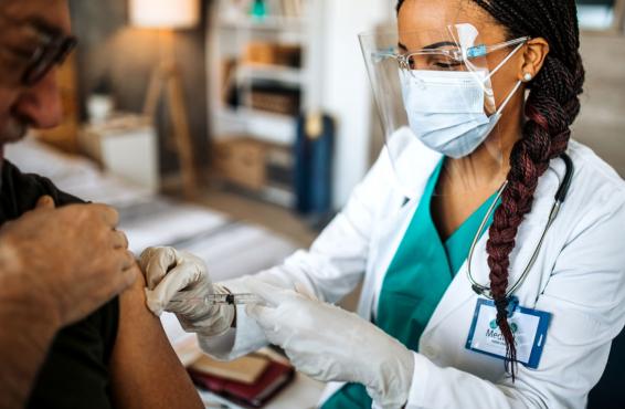 Health care worker administering vaccine