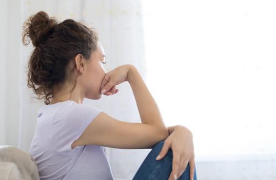 Person sitting resting head in hand