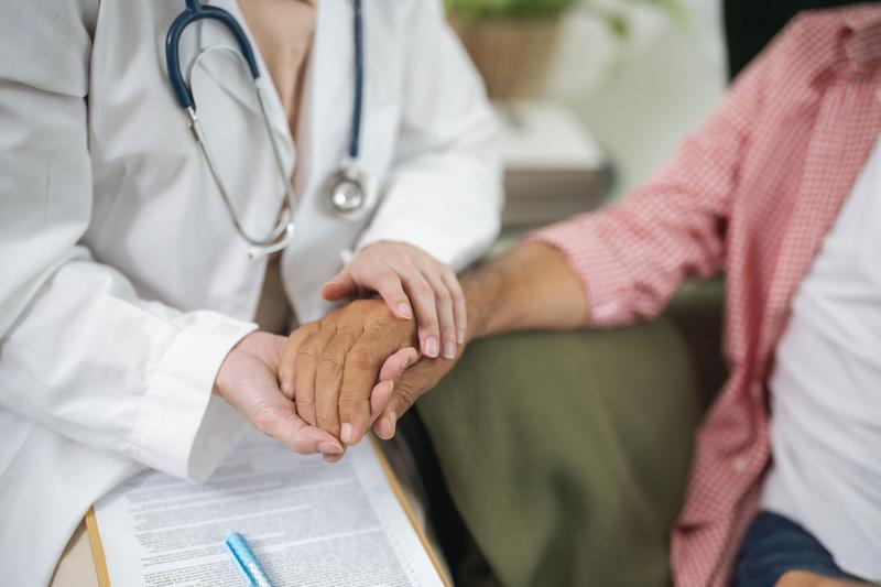 Health care worker holding a patient's hand