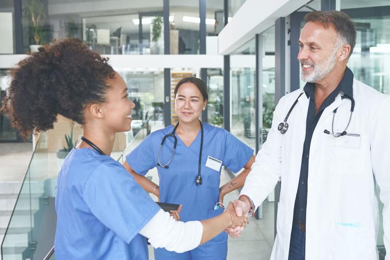 Smiling health care workers shaking hands