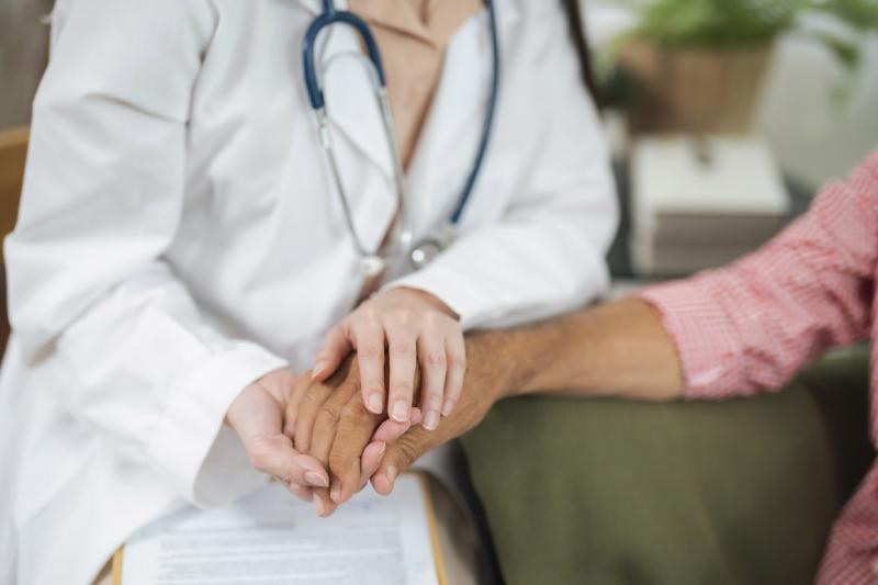 Doctor holds patient's hand