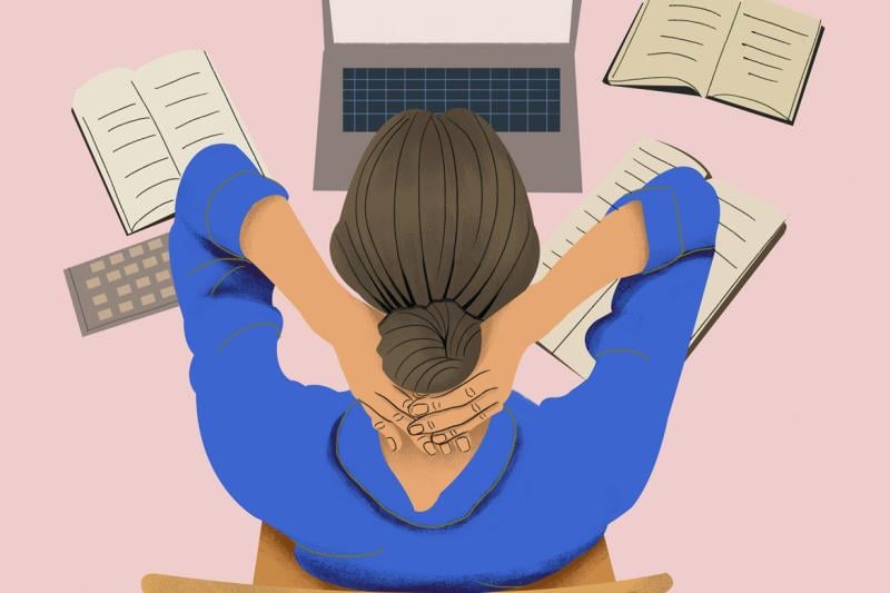 Figure working at laptop with hands behind head