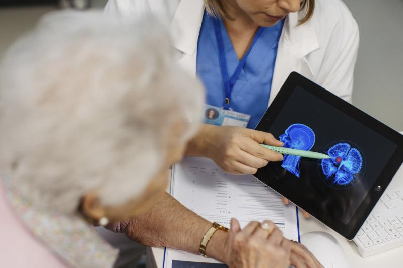 Doctor explaining results of MRI scan of brain to senior patient