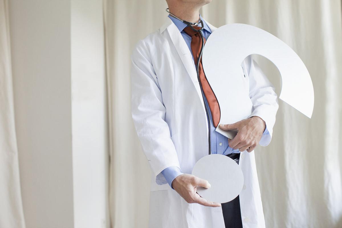 Physician holding a large question mark